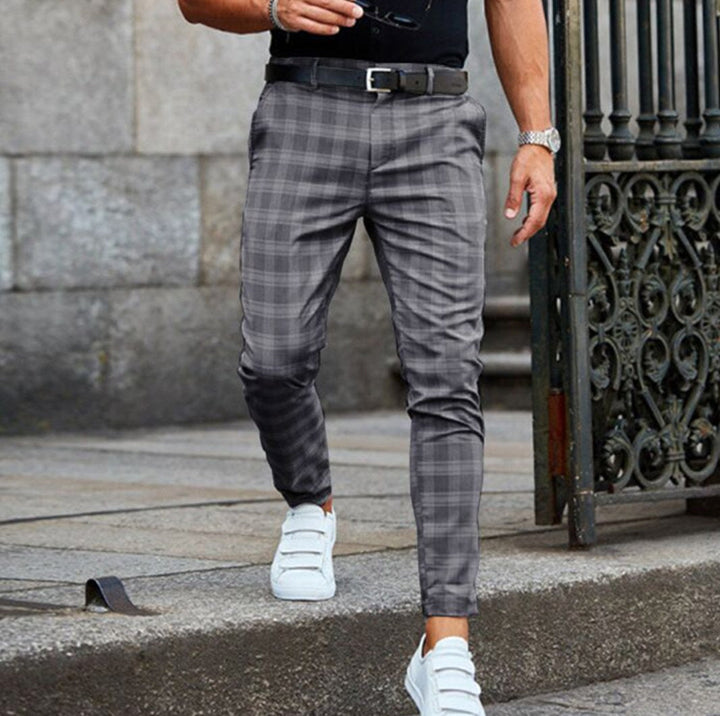 Man wearing gray check trousers with white sneakers outdoors