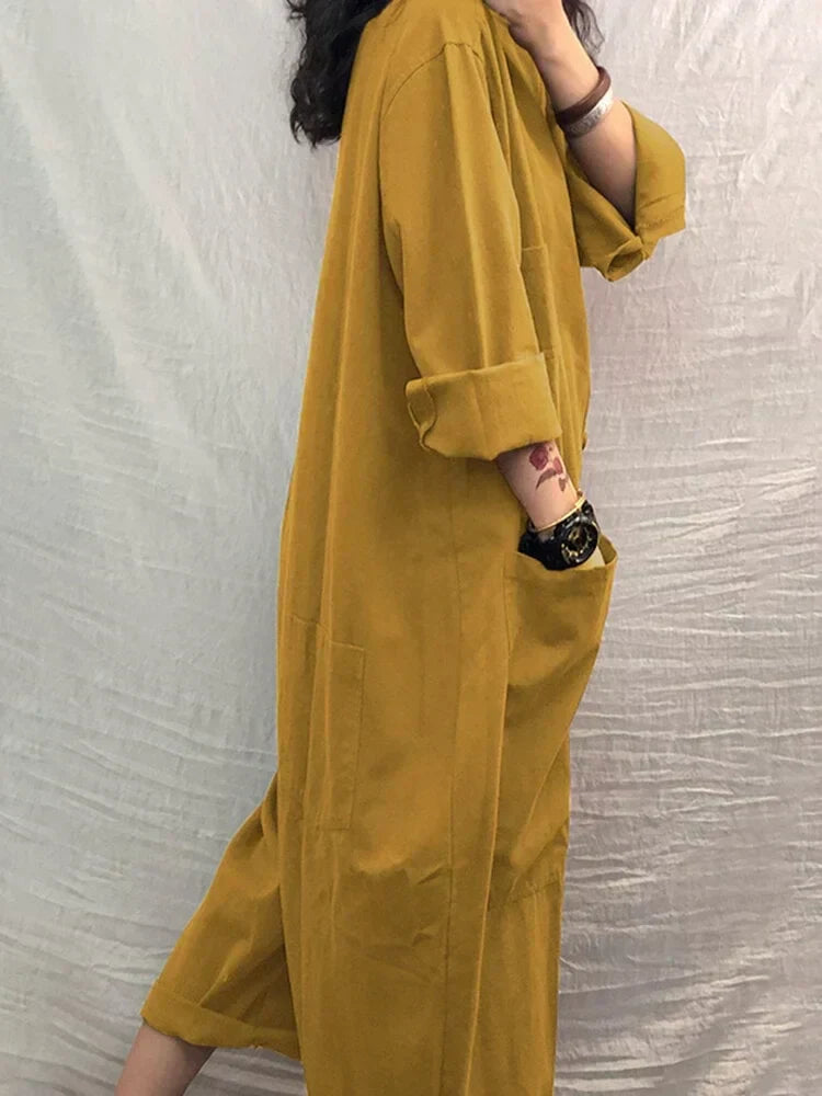 Side view of a woman wearing a yellow summer jumpsuit with rolled sleeves