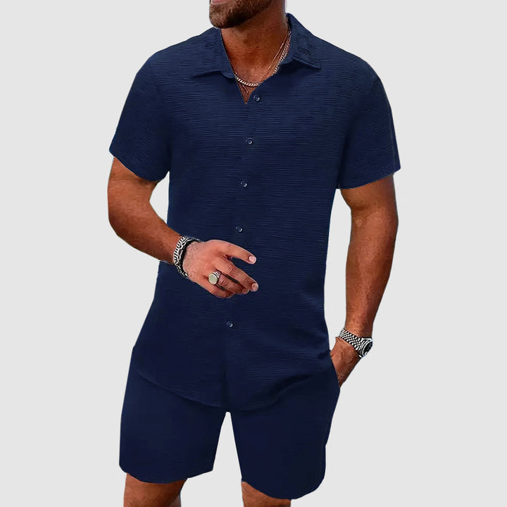 Man wearing blue short sleeve button down shirt and matching shorts set