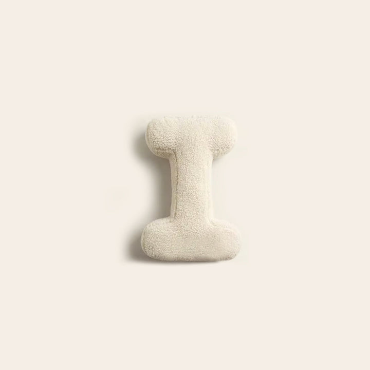 Plush letter cushion home decor accessory on armchair