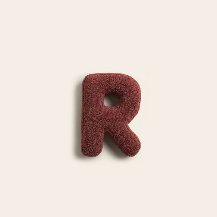 Multiple letter pillows and decorative alphabet cushions stacked