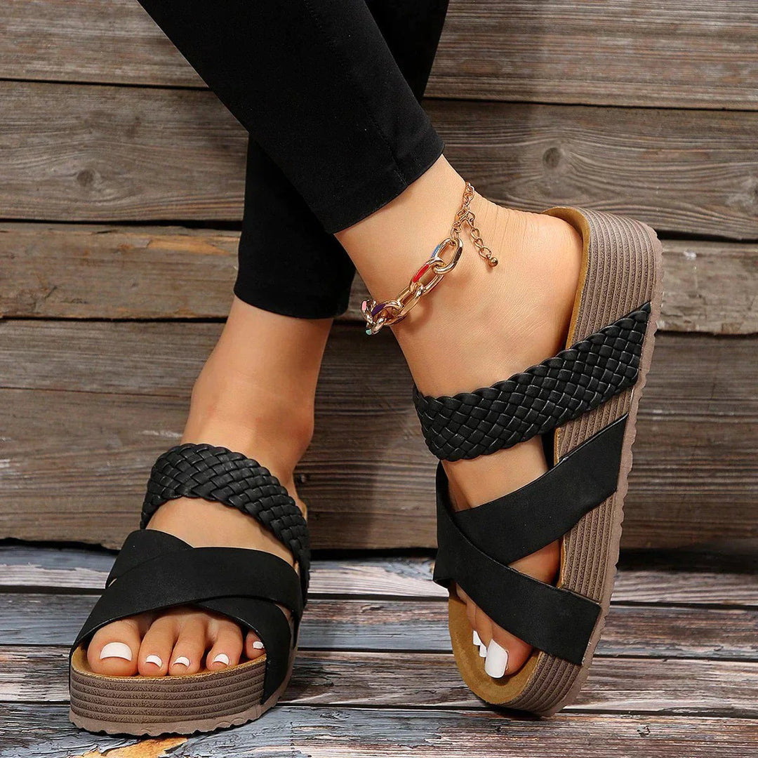 Woman wearing black platform slip-on sandals with comfortable elastic side panels