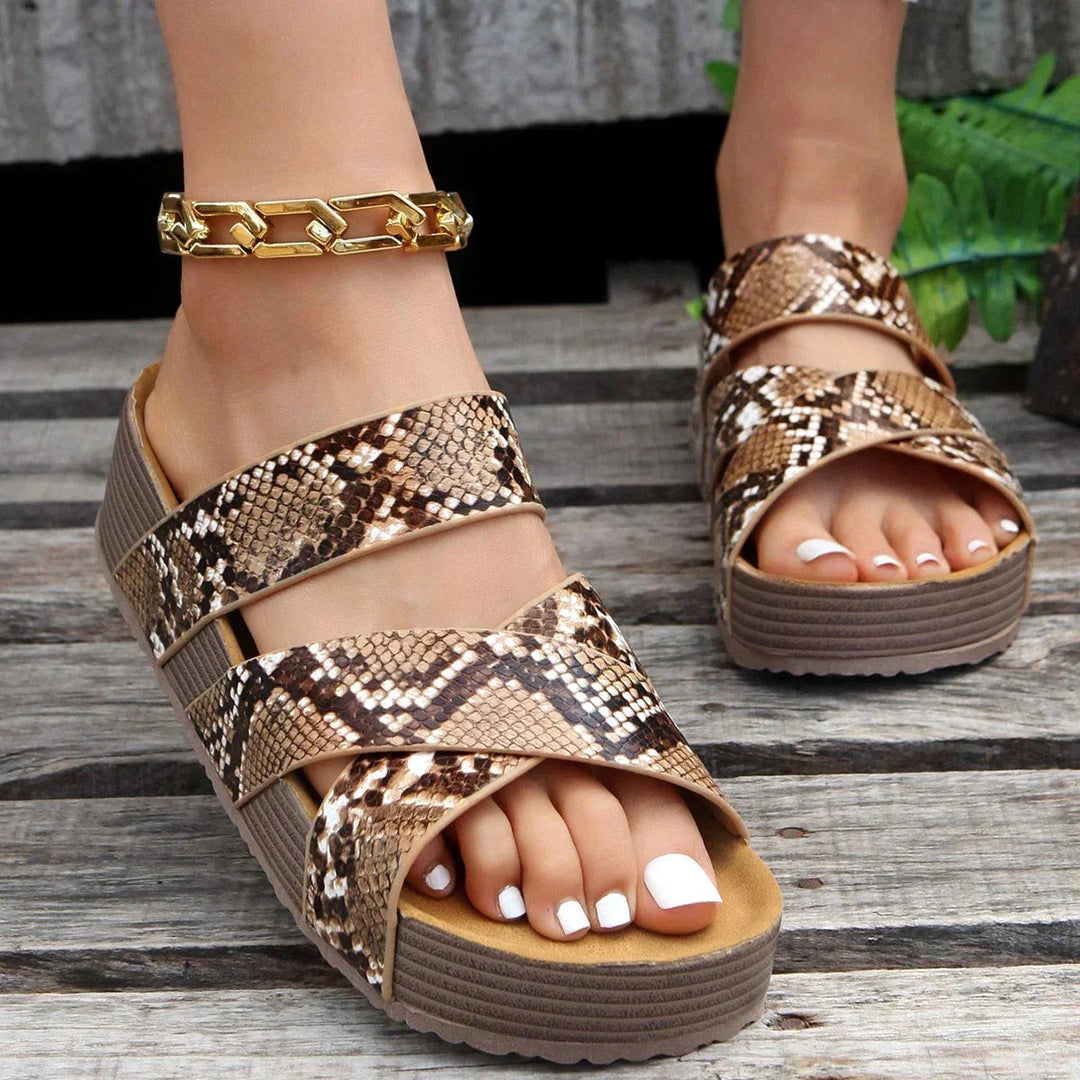 Detailed view of brown pattern platform slide sandals on a wooden surface