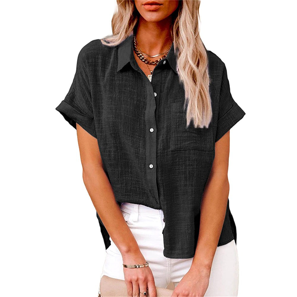 Woman wearing a black button-front short sleeve blouse paired with white trousers