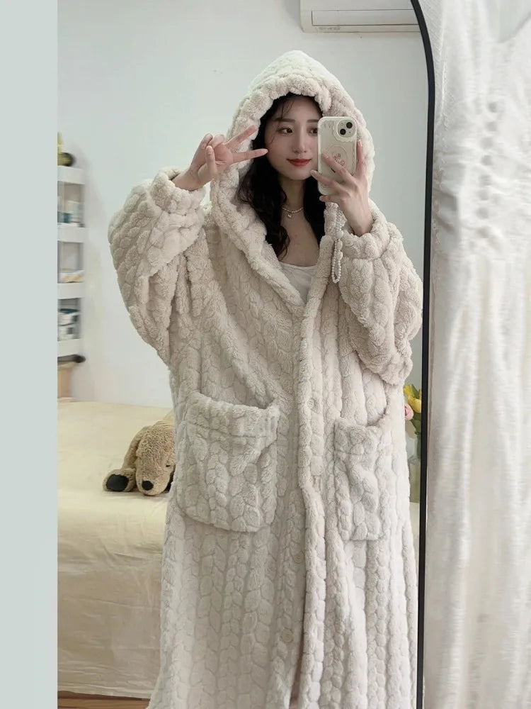 Woman wearing white hooded bathrobe with front pockets taking mirror selfie