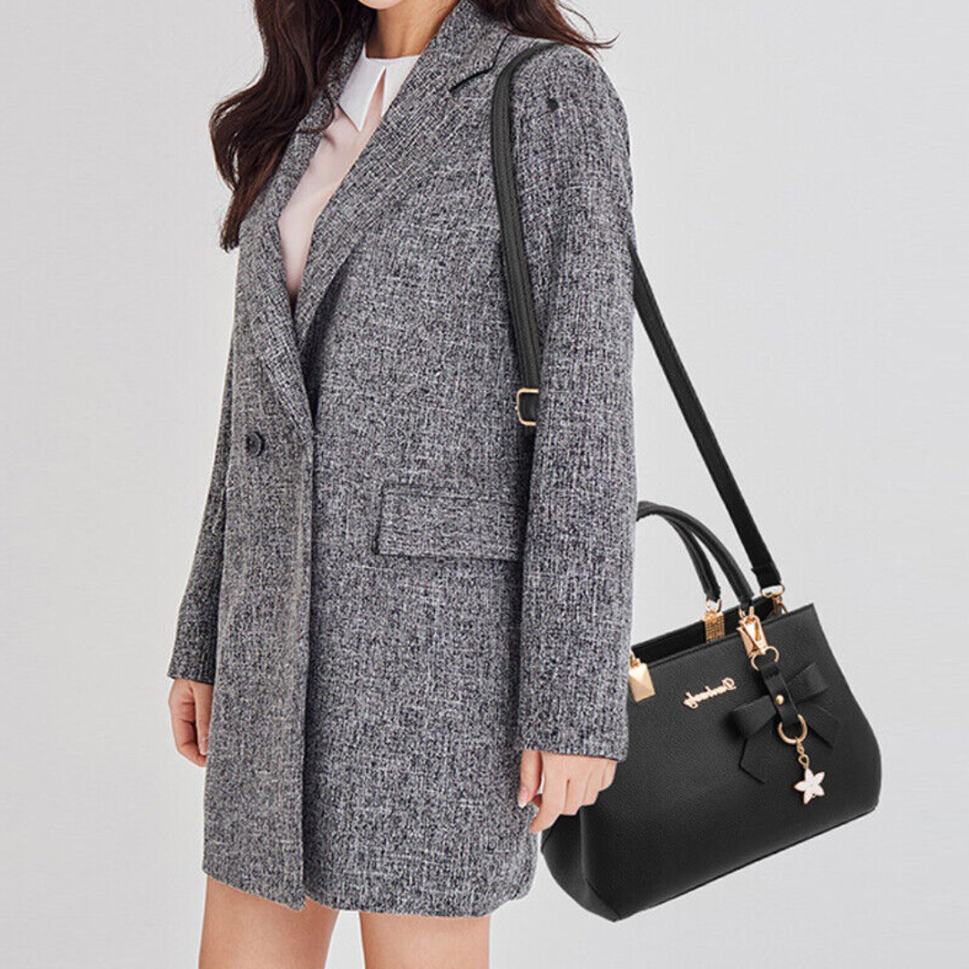 Black Anna crossbody bag worn by a model in a grey tweed jacket