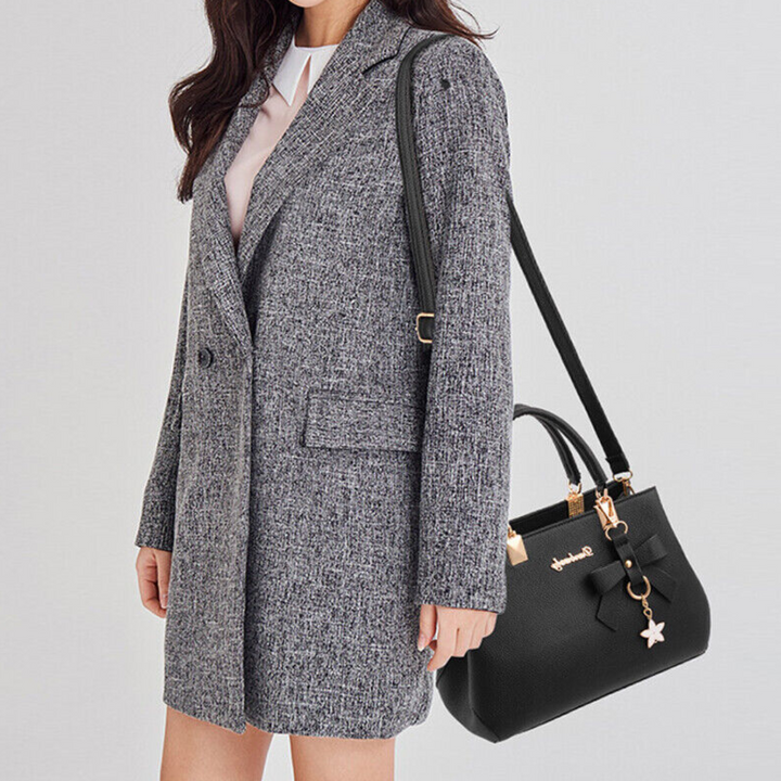 Black Anna crossbody bag worn by a model in a grey tweed jacket