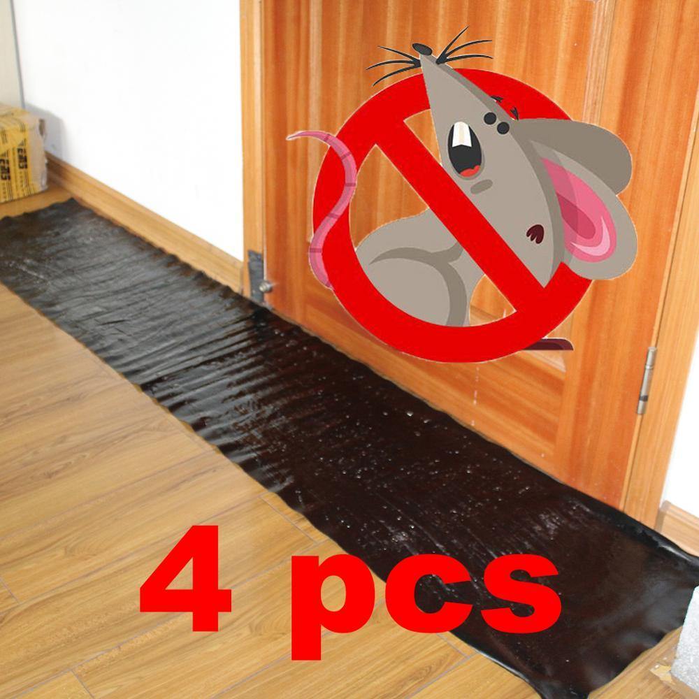 Large black adhesive rat trap mat placed on a wooden floor near a doorway