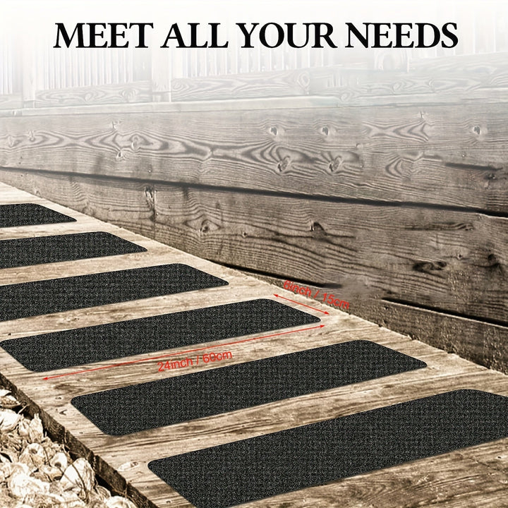 Multiple black anti-slip stair treads installed on an outdoor wooden walkway