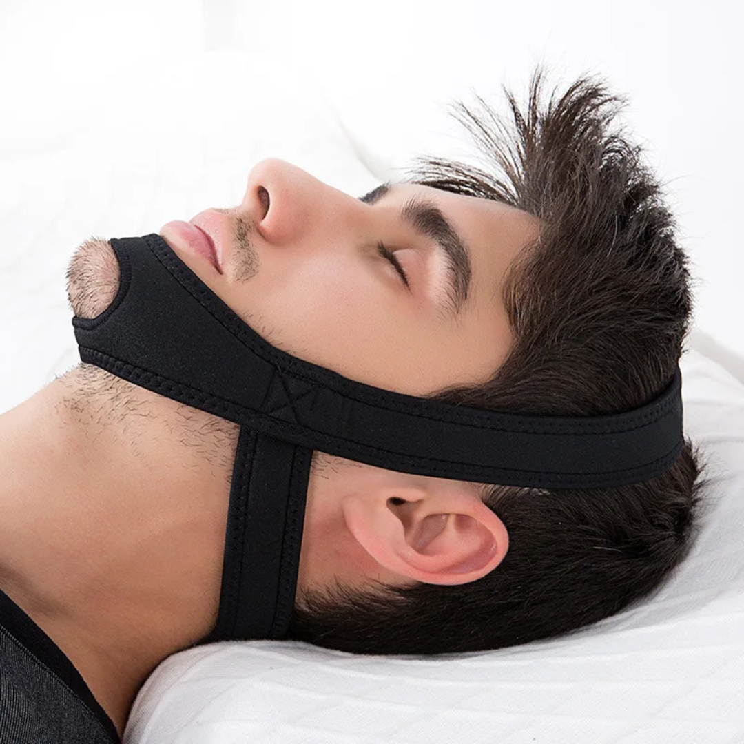 Man sleeping comfortably while wearing the black anti-snoring chin strap