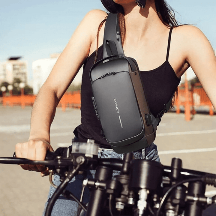 Person wearing the black anti-theft chest bag while riding a motorcycle outdoors