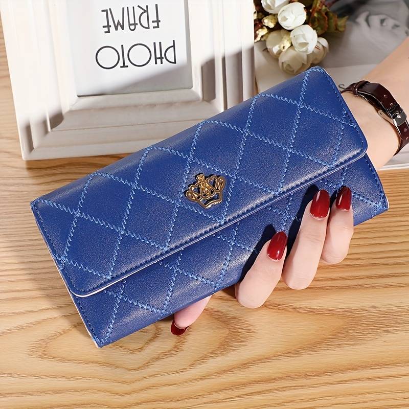 Blue women's argyle pattern trifold wallet with gold crown accent held in hand