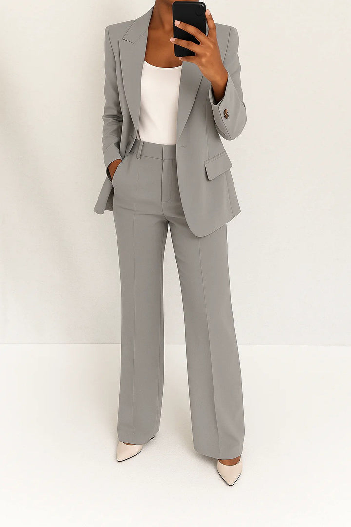 Woman wearing grey wide-leg tailored blazer trouser suit in a bright setting