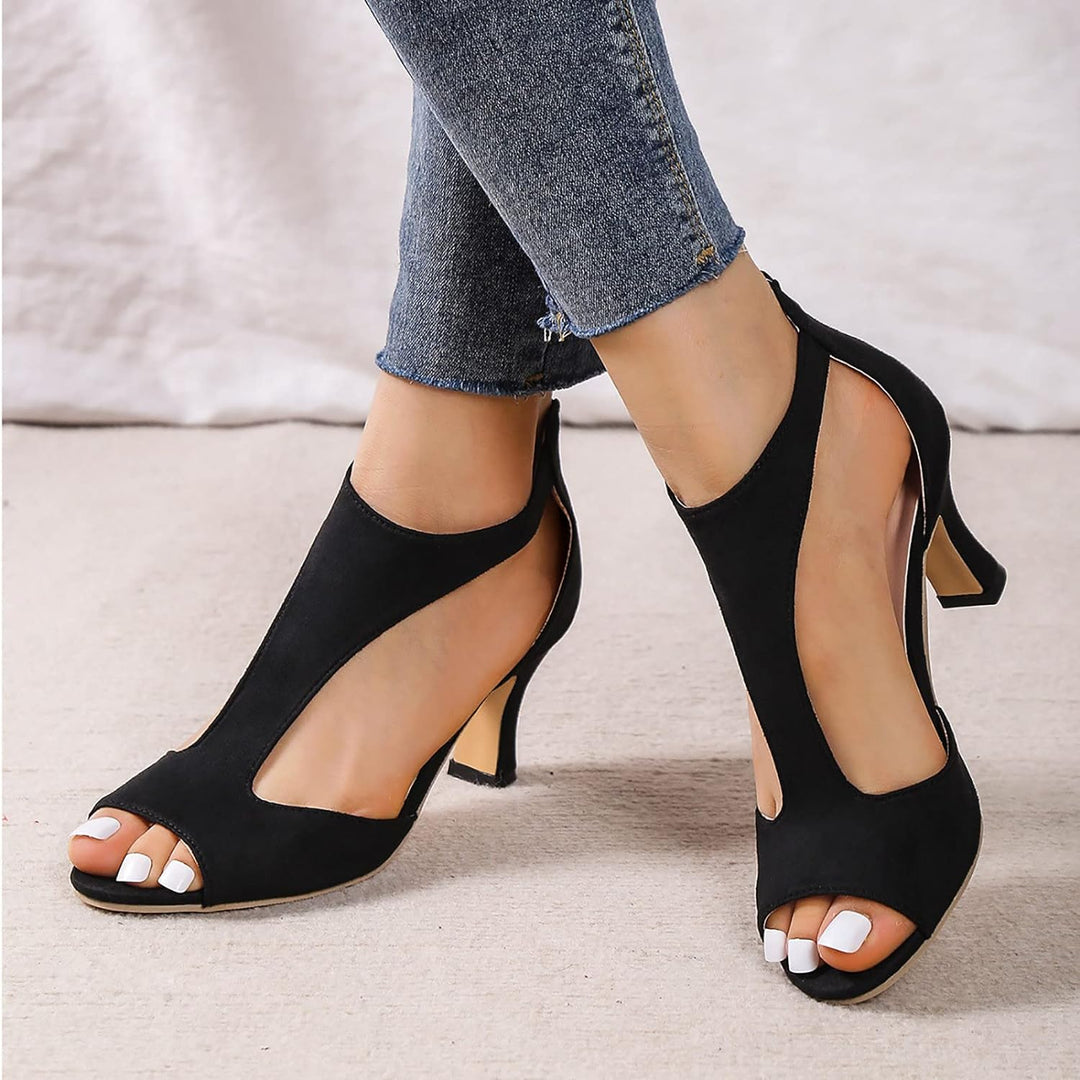 Close-up of black open toe heeled sandals worn with blue jeans