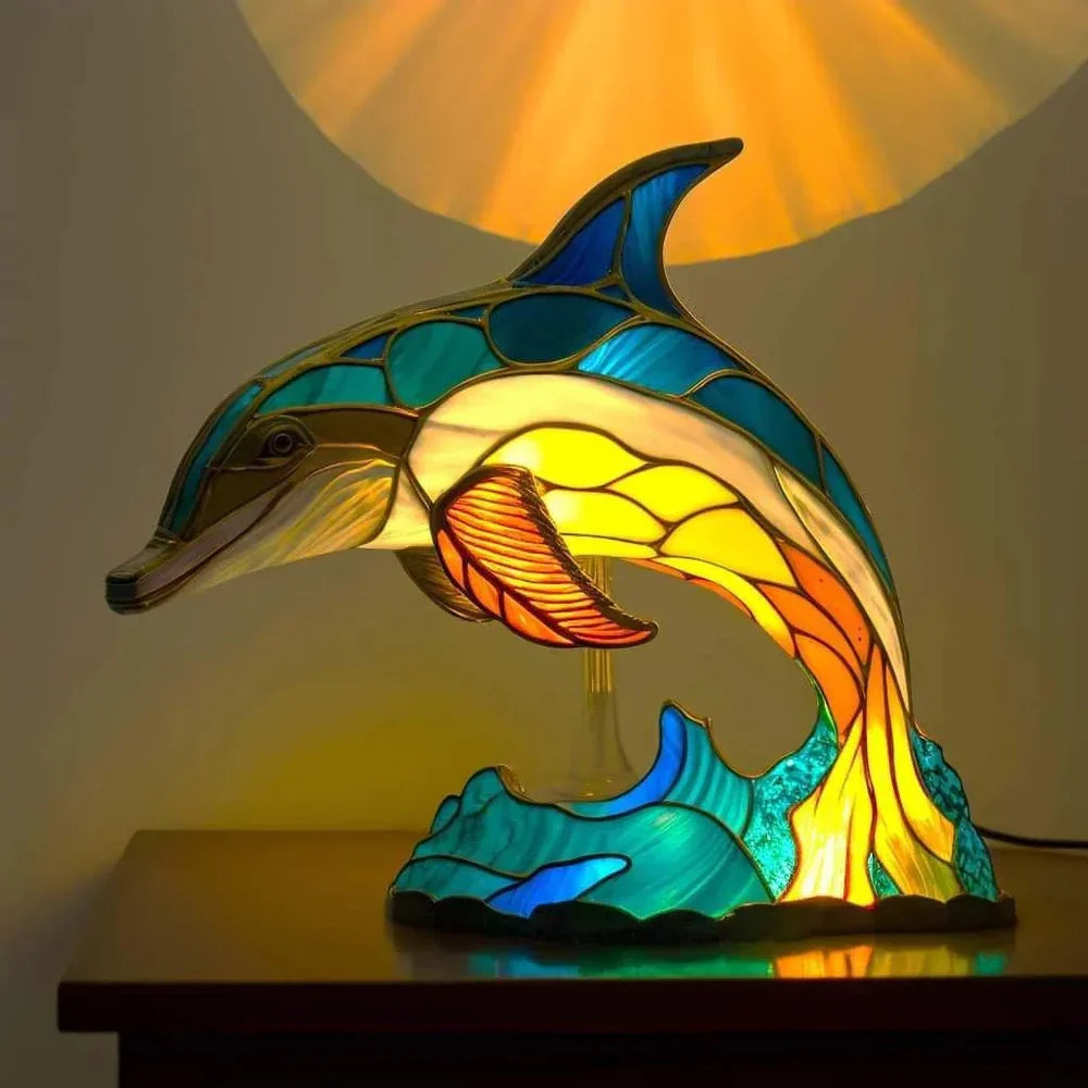 Stained glass dolphin table lamp glowing with blue and yellow light