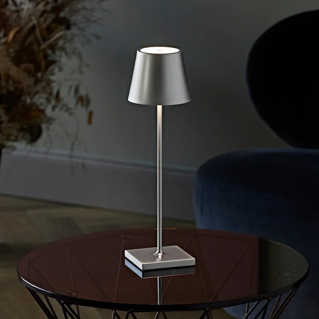 Portable LED table lamp illuminated on a bedside nightstand