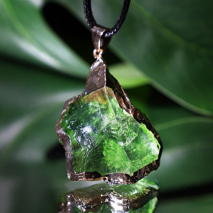 Detailed shot of the unique irregular shape and deep green colour of the moldavite crystal