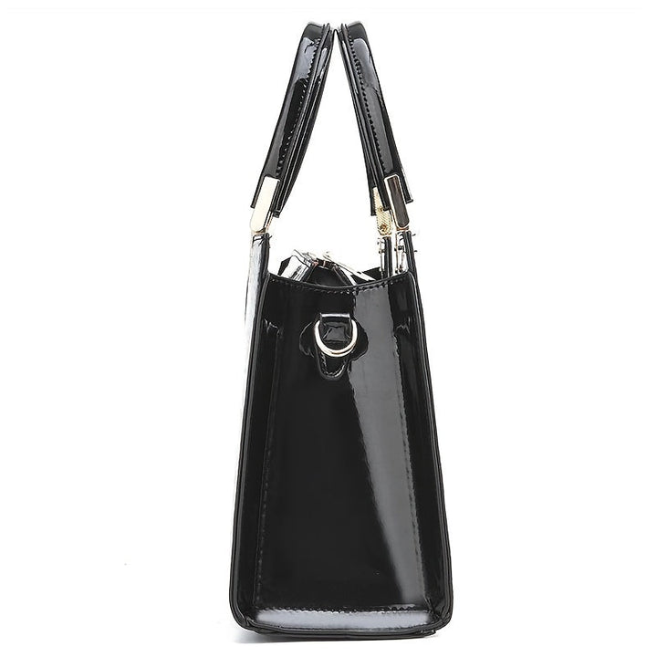 Side profile of the black handbag showing width and attachment ring for the shoulder strap