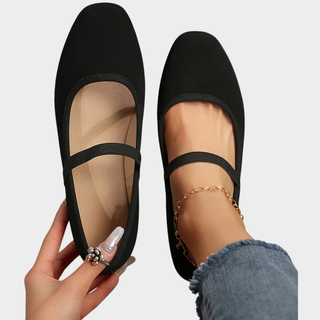 Top-down view of black slip-on ballet flats with elastic strap