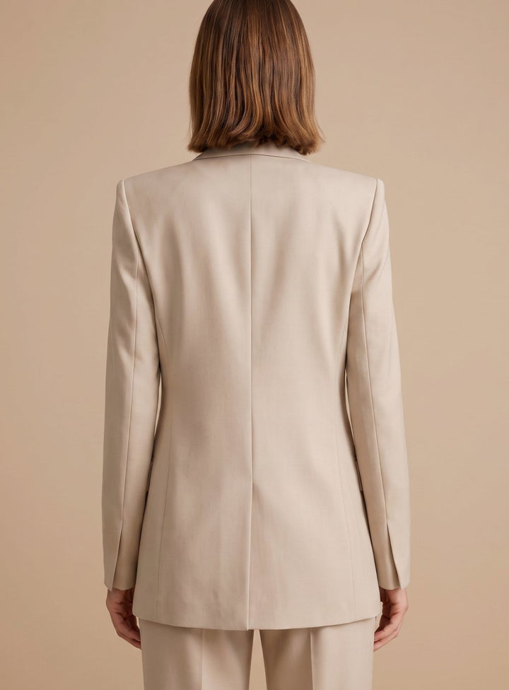 Back view of woman wearing beige tailored blazer and trousers suit