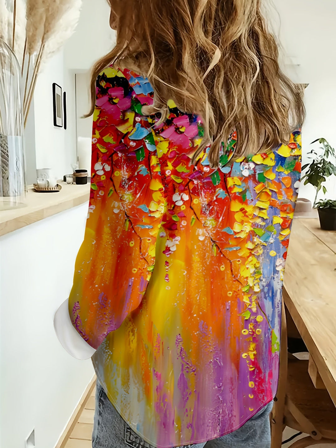 Back view of a woman wearing the colorful botanical print button-up shirt.