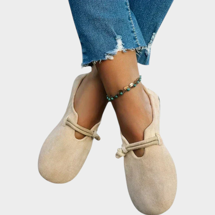 Close-up of beige flat shoes worn with blue jeans