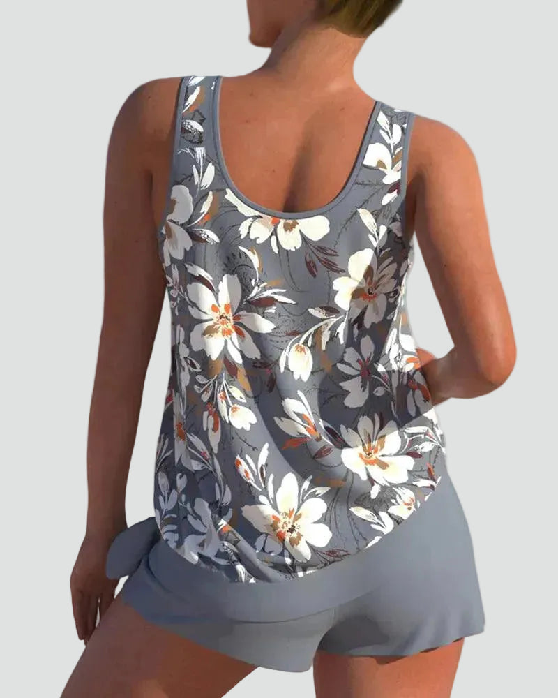 Back view of a woman showcasing the back of the grey floral print tankini top