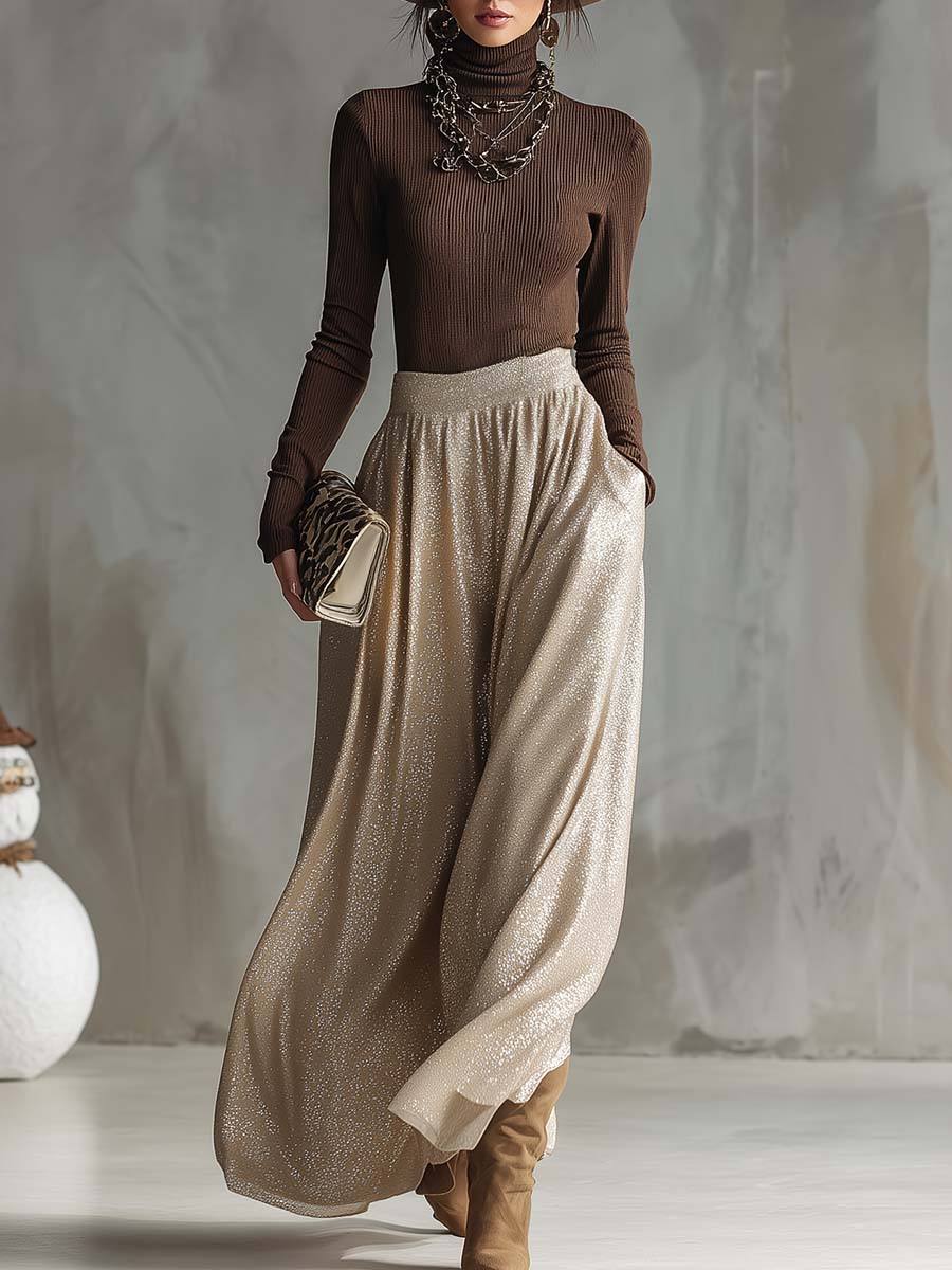 Model wearing a brown ribbed knitted top and a shimmering silver skirt with a handbag.