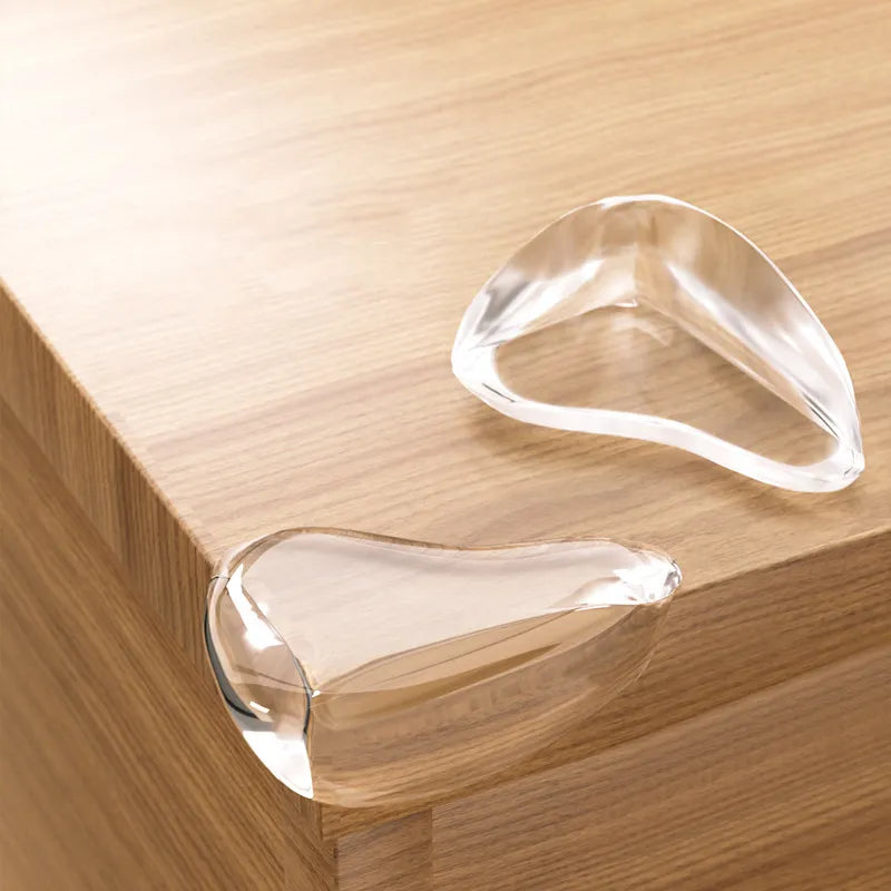 Clear silicone corner protectors installed on a wooden table edge