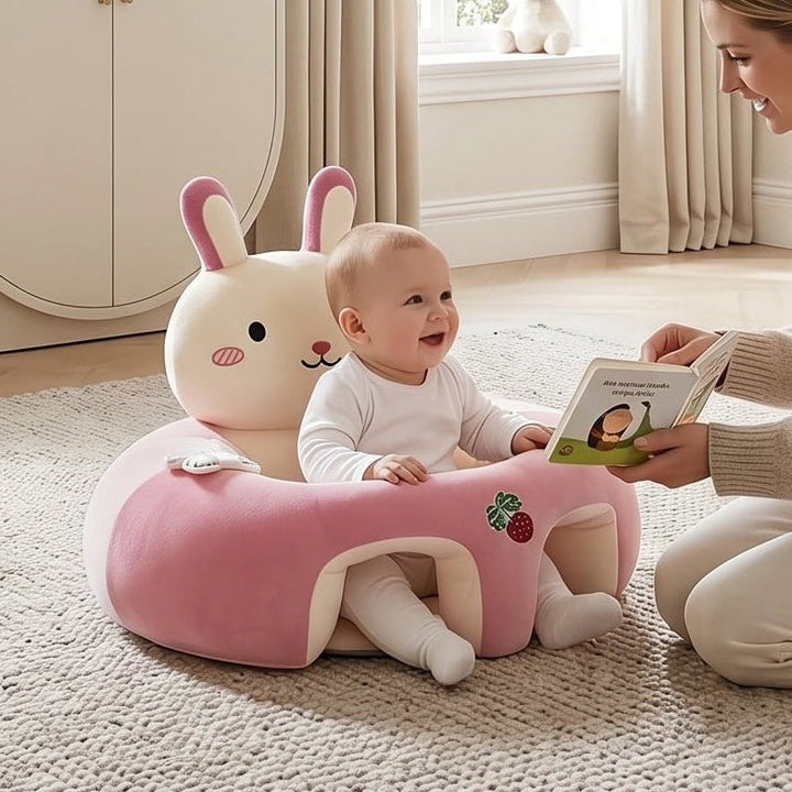 Baby smiling while sitting in a pink Little Rabbit support seat on a rug
