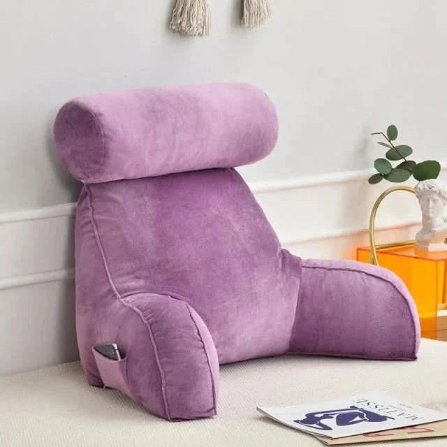 Ergonomic bed reading pillow with supportive arms for upright lounging and relaxing