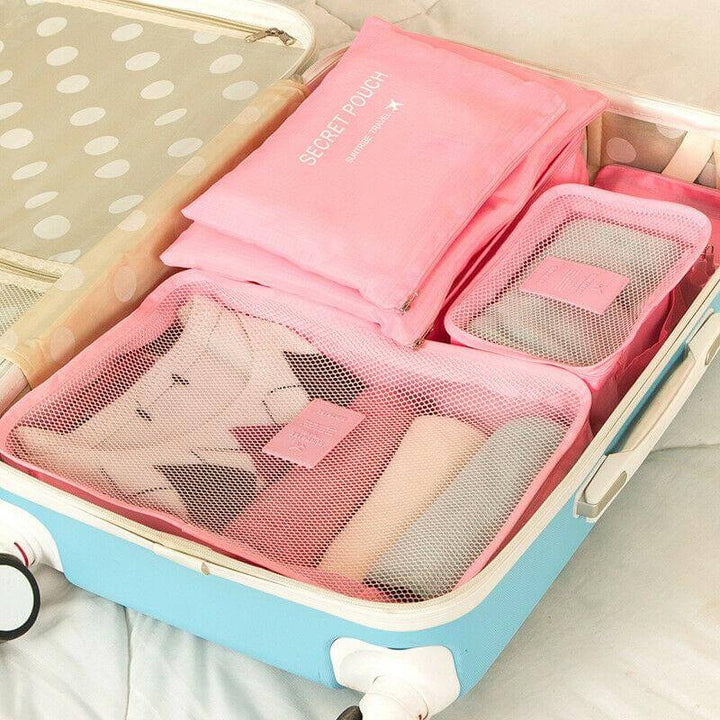Close-up of pink travel packing cubes filled with clothing inside a suitcase