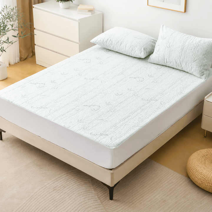 Light green adjustable cooling sheet spread neatly across a modern bed in a bright bedroom