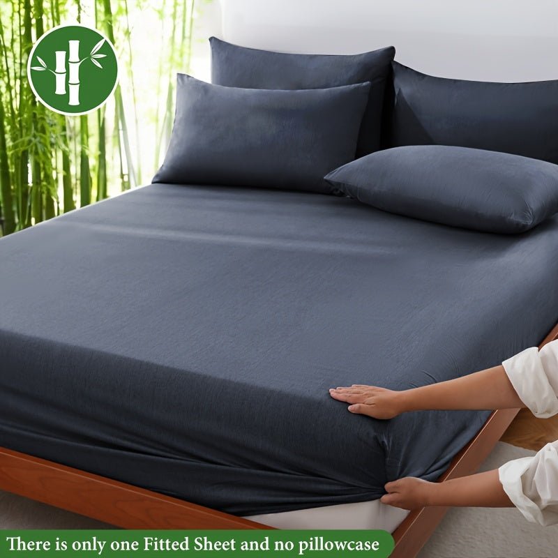 Dark gray bamboo fiber fitted sheet on a modern bed with pillows