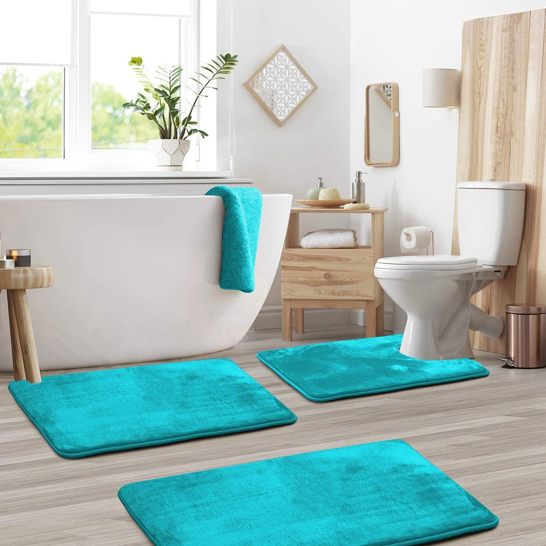 Blue-green 3-piece memory foam bathroom mat set in front of a white bathtub