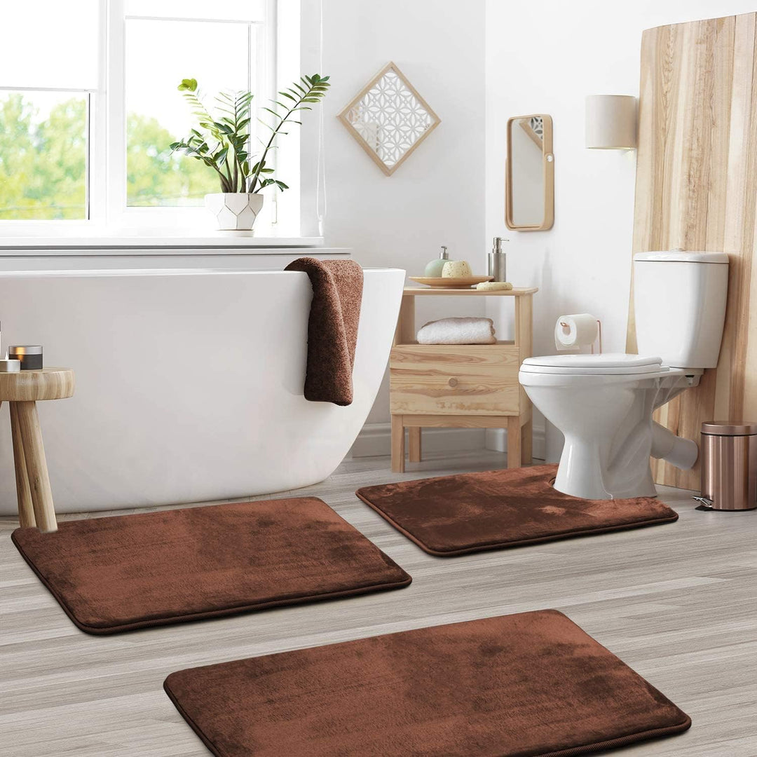 Brown 3-piece memory foam bathroom mat set arranged on a light wood floor