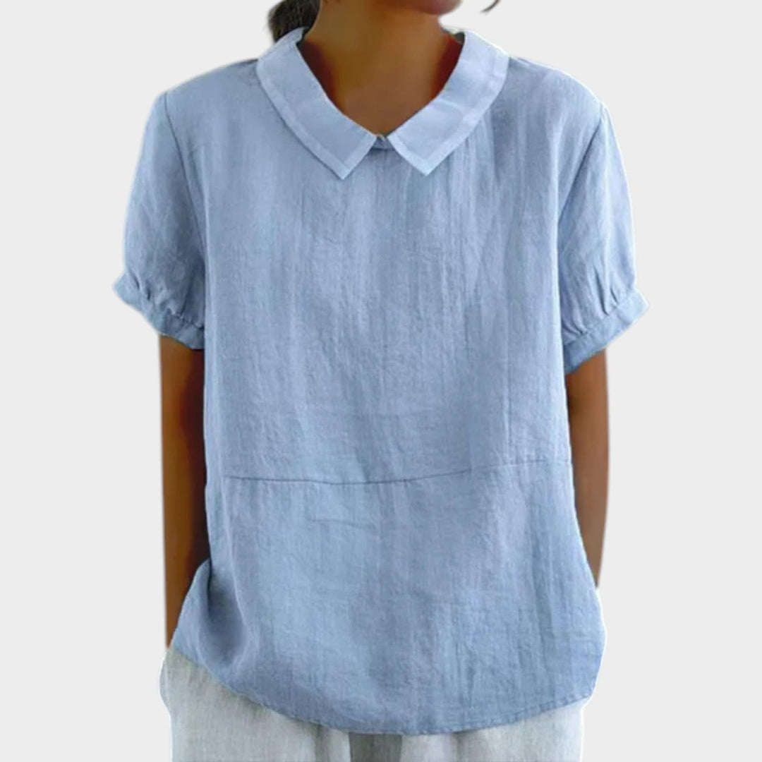Woman wearing blue collared short sleeve blouse with relaxed fit