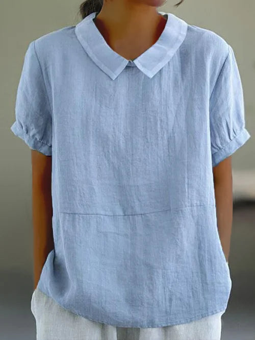 Woman wearing a light blue short sleeve shirt with a classic collar