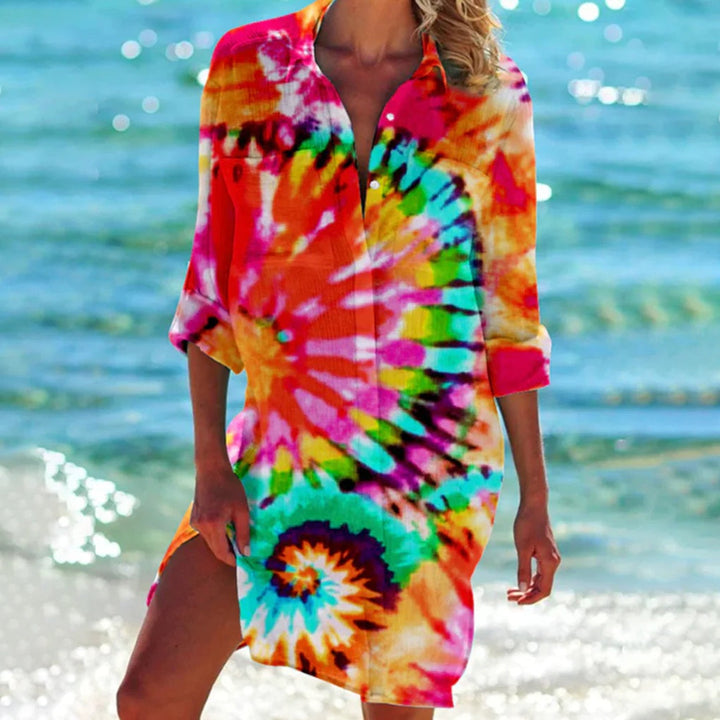 Woman wearing vibrant orange tie-dye beach shirt at the seaside