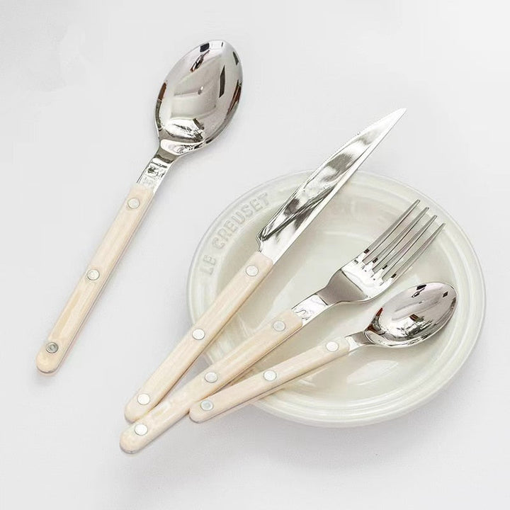 Durable kitchenware spoon resting on a sleek porcelain plate