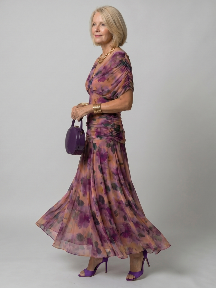Woman modeling the floral ruched midi boho dress in purple profile view