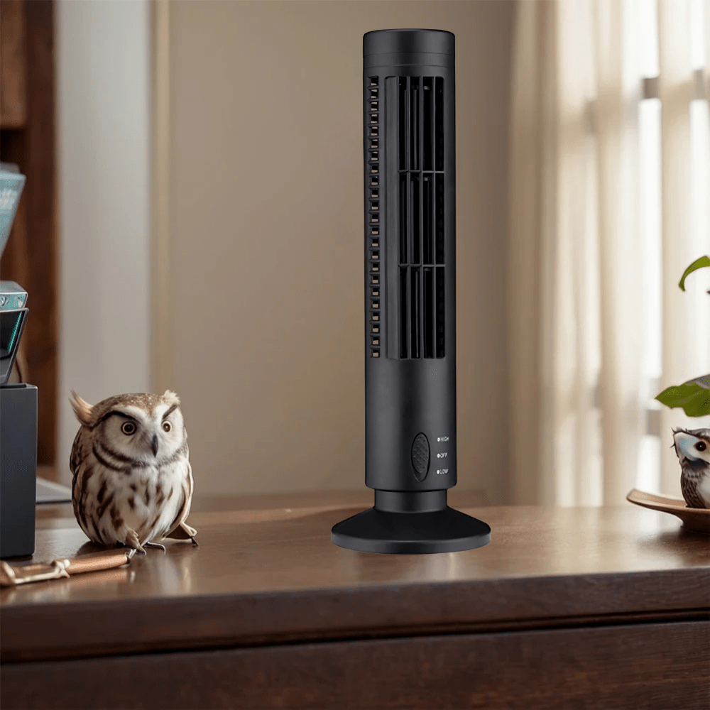 Black bladeless tower cooling fan placed on a wooden desk next to a small owl figurine.