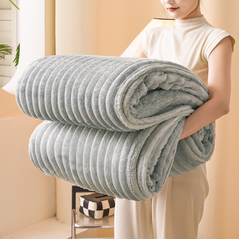 Light grey chunky knit throw blanket folded neatly being held up