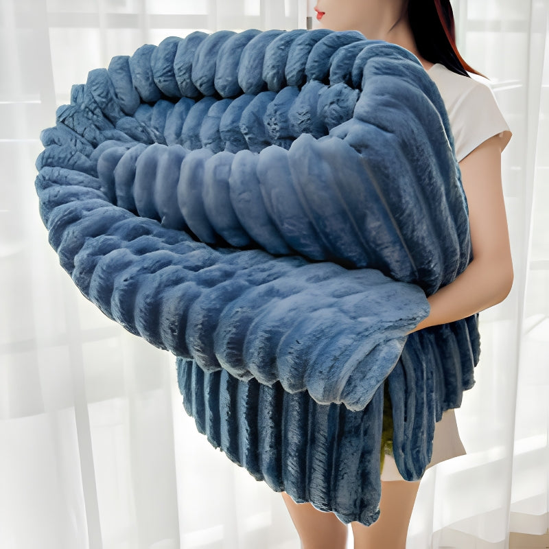 Neutral colored chunky knit throw blanket accenting a modern minimalist living room.
