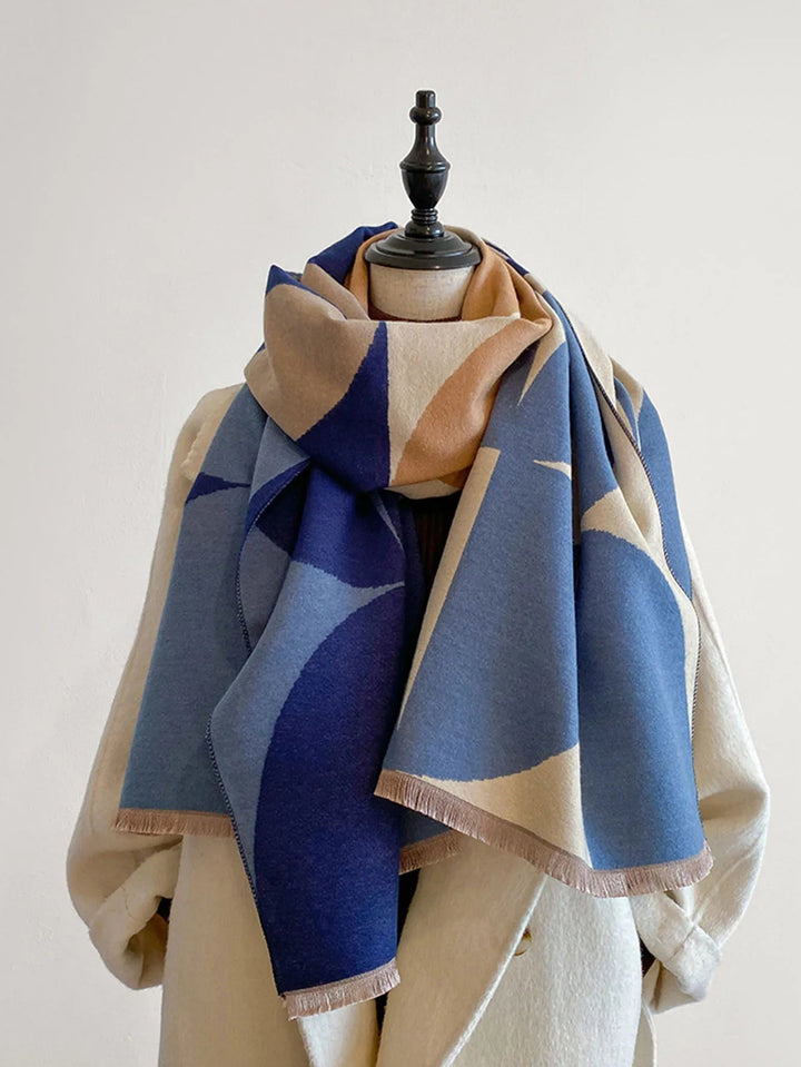 Blue and beige patterned reversible soft wrap scarf displayed on a mannequin
