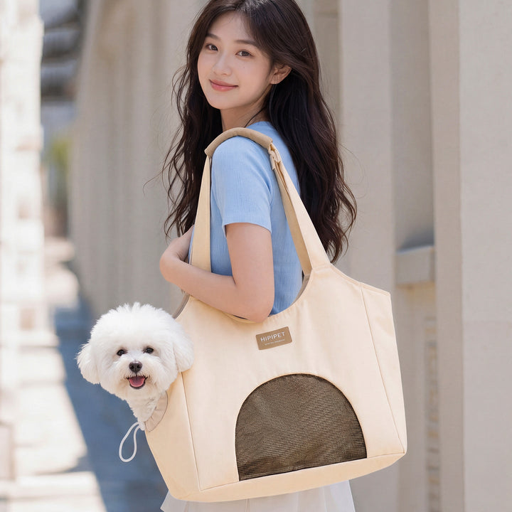 Woman carrying a white pet carrier bag with a small dog inside