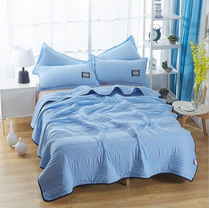 Unisex breathable summer cooling blanket folded neatly, showcasing lightweight quilt texture and home textiles design.