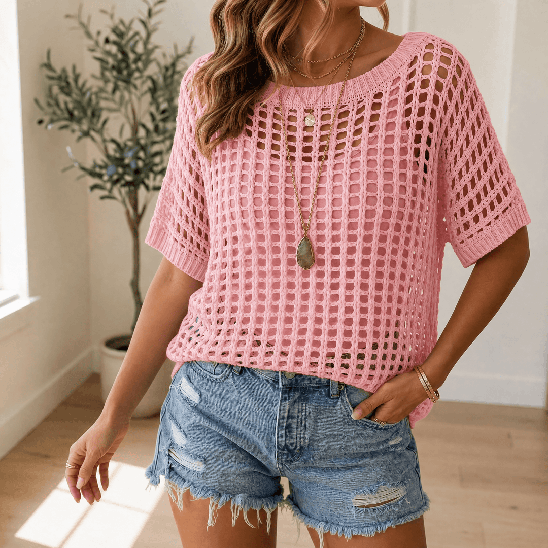Woman wearing a pink open-knit short sleeve summer top in a bright room