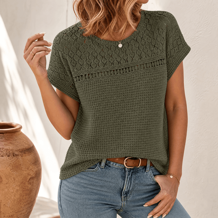 Woman wearing an olive green open-weave short sleeve summer top with denim jeans.