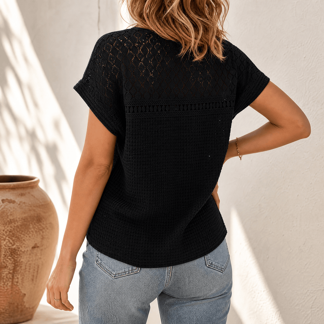 Back view of a woman wearing a black open-weave short sleeve summer top.